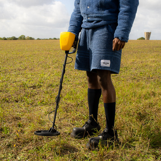 Person with a metal detector in a field